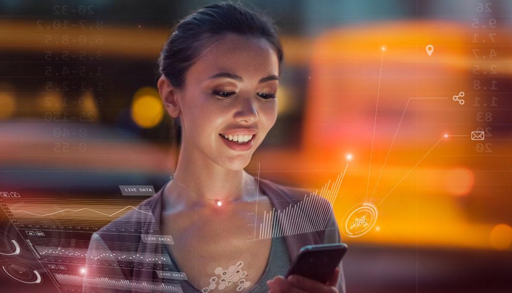A Woman is Smiling While Looking at Her Cell Phone