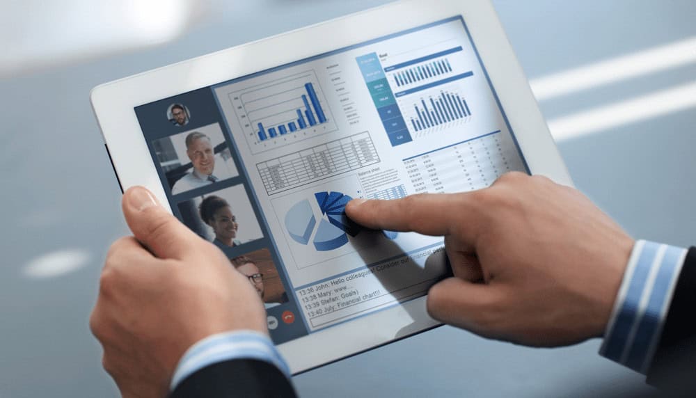a person is holding a tablet with graphs on it