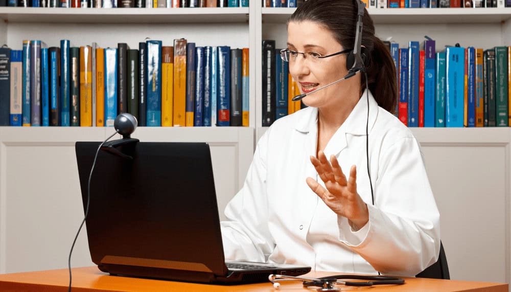 a doctor wearing a headset talks on a video call